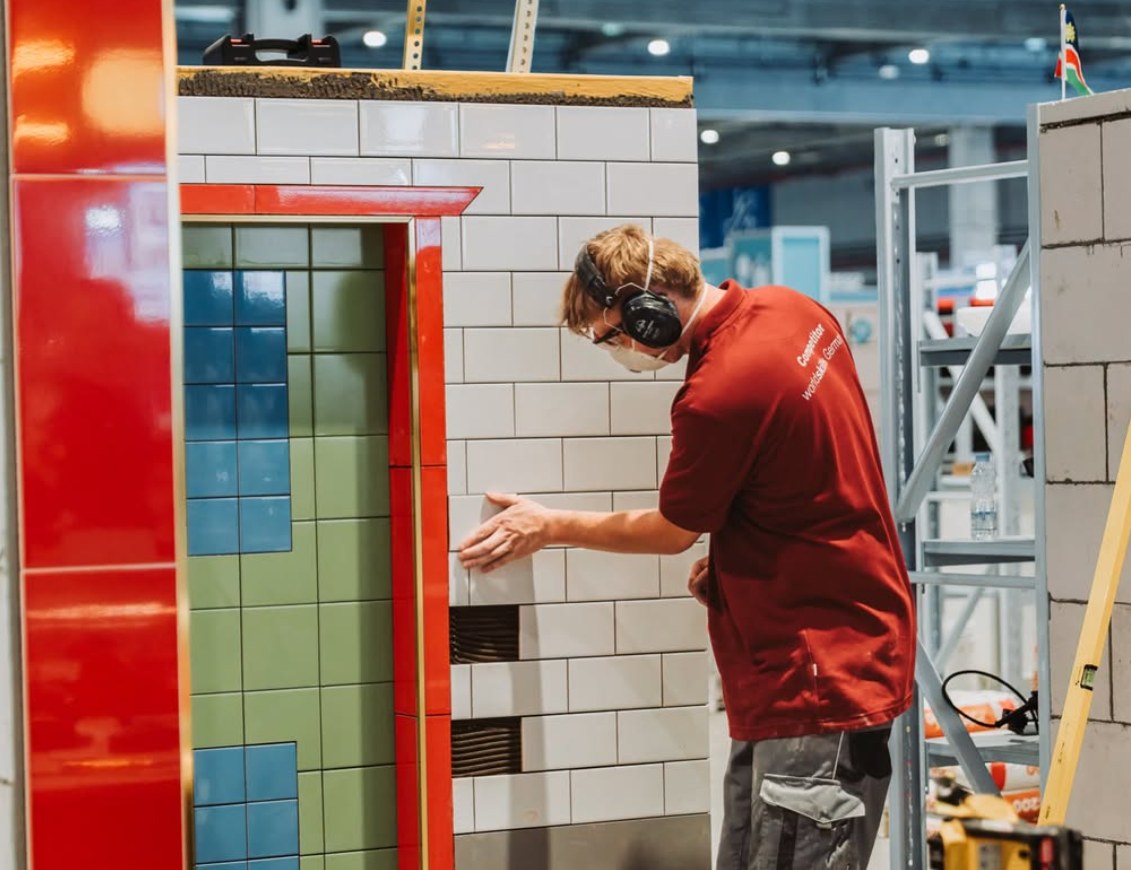 Niko Schleicher verlegt weiße Wandfliesen bei den WorldSkills in Shanghai